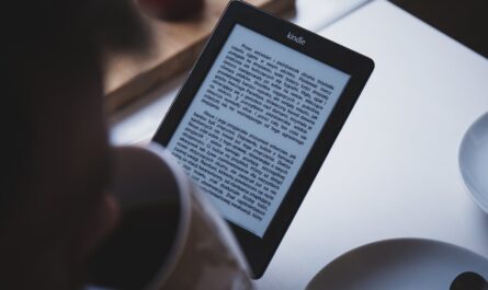 person using e book reader while drinking coffee