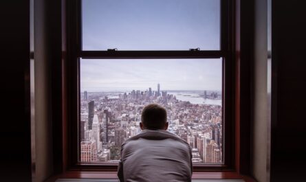 man in gray shirt looking at city buildings